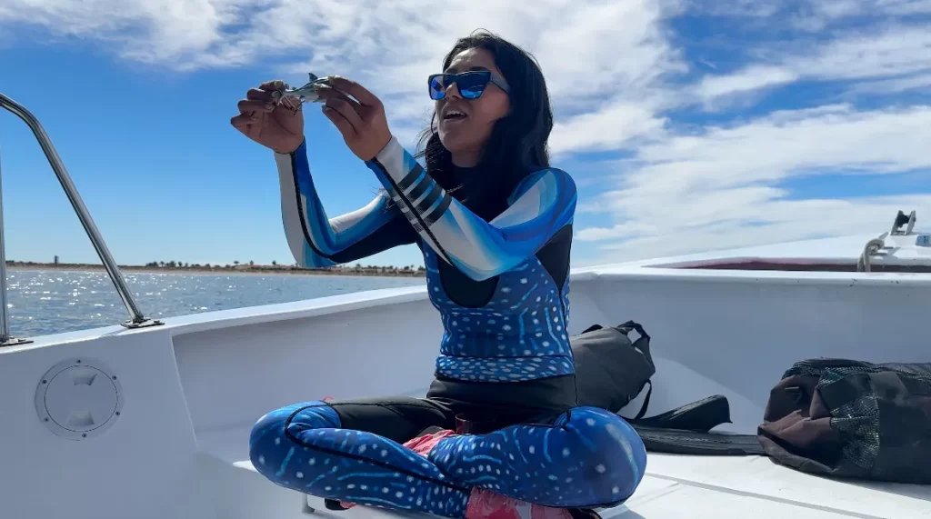 guide giving a talk on the whale sharks while holding a whale shark in her hand