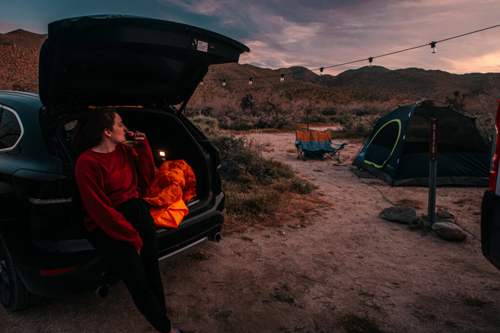 girl sitting in car in front of campsite at Yaqui Wash