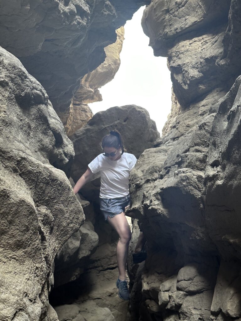 girl climbing the slot canyon in anza borrego