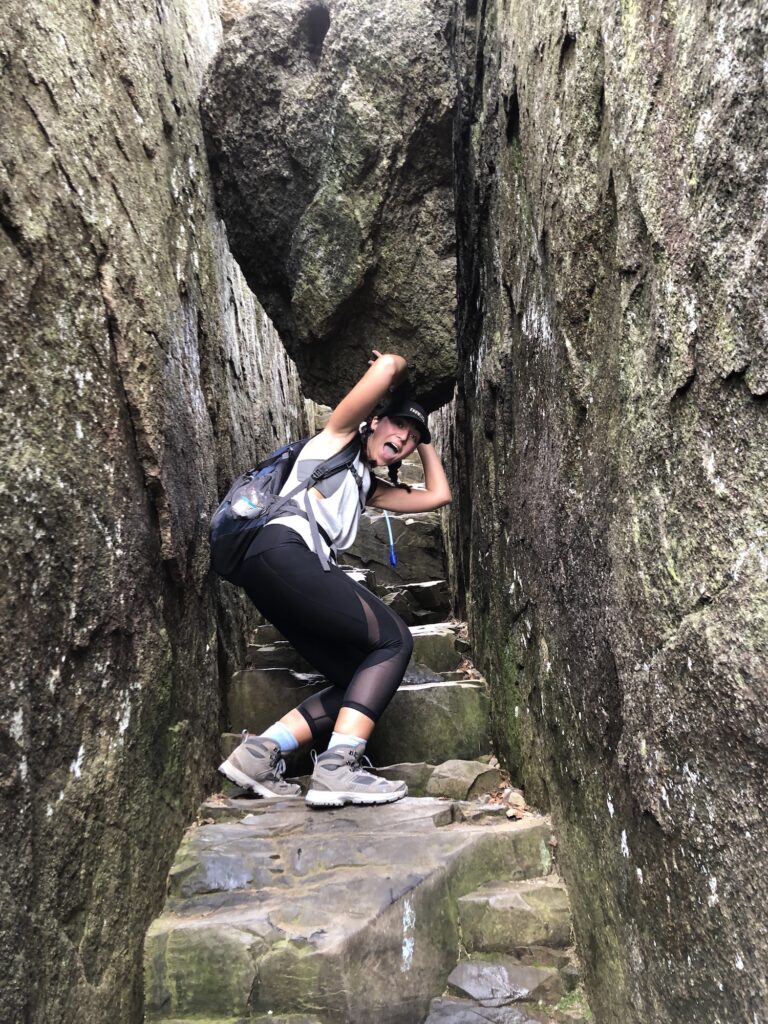 girl holding up a boulder with stairs behind her
