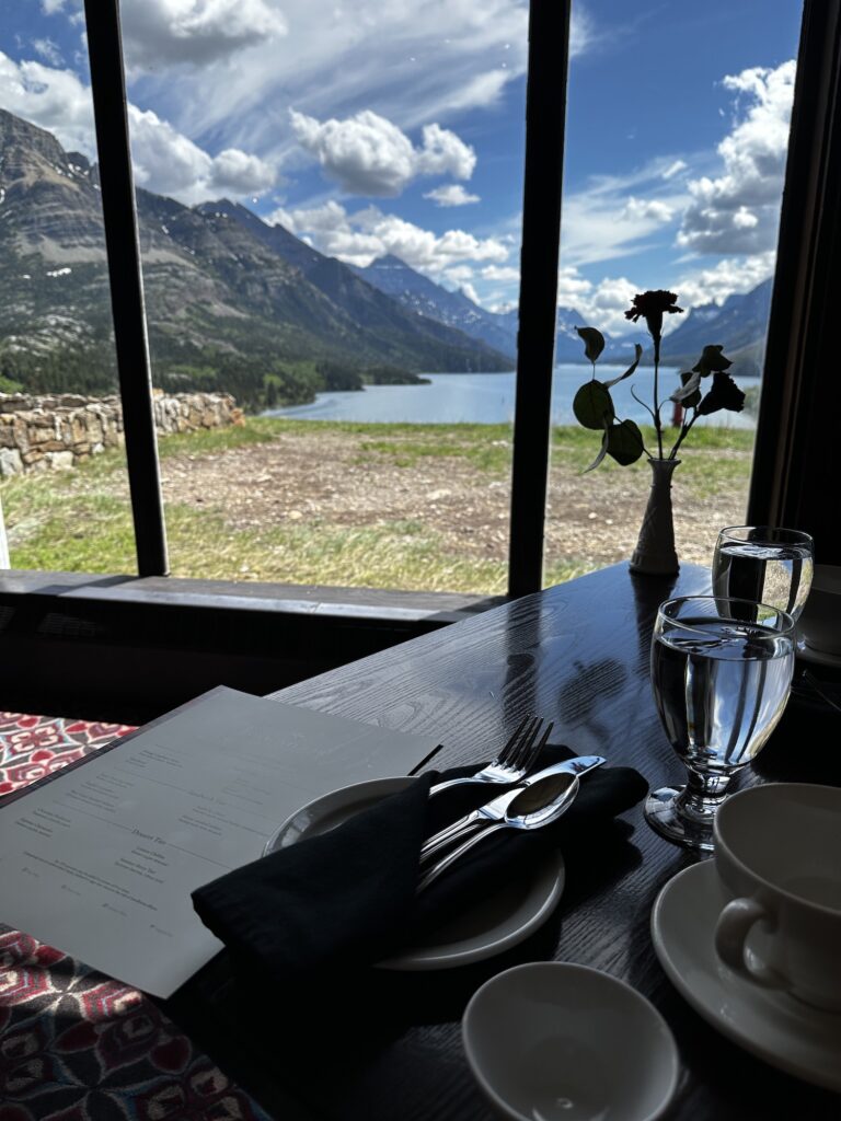 table set up with a window behind overlooking mountains and bright blue lake