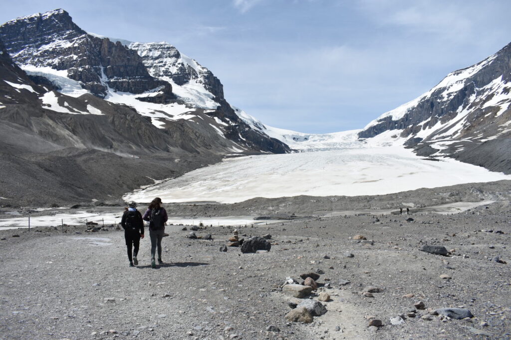 two girls walking towards athabasca glacier