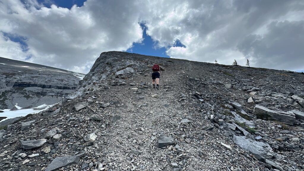 boy hiking up a large pile of scree