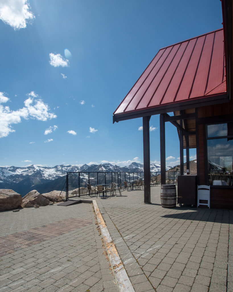 Eagle's Eye restaurant at the top of the mountain summit set up with chairs and mountains behind