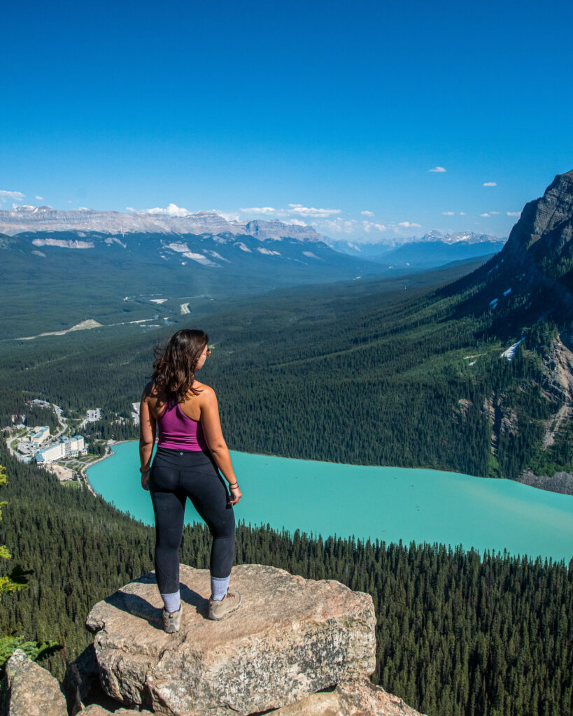 Girl looking out over a lake below with hotel