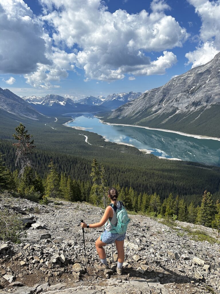 girl standing on trail overlooking spray lakes and mountains