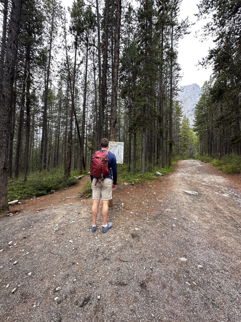 boy standing in front of trail sign for Grassi Lakes