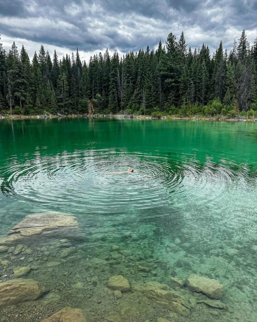 girl floating in a greenish clear lake