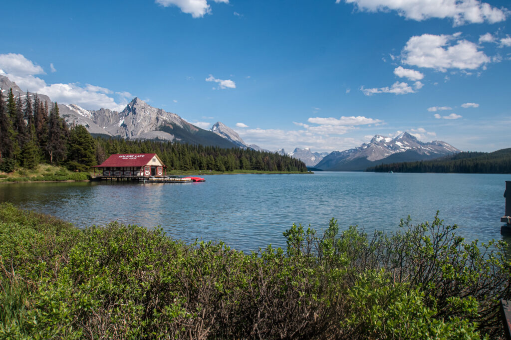 Maligne Lake with blue color a boathouse on the shore and mountains behind