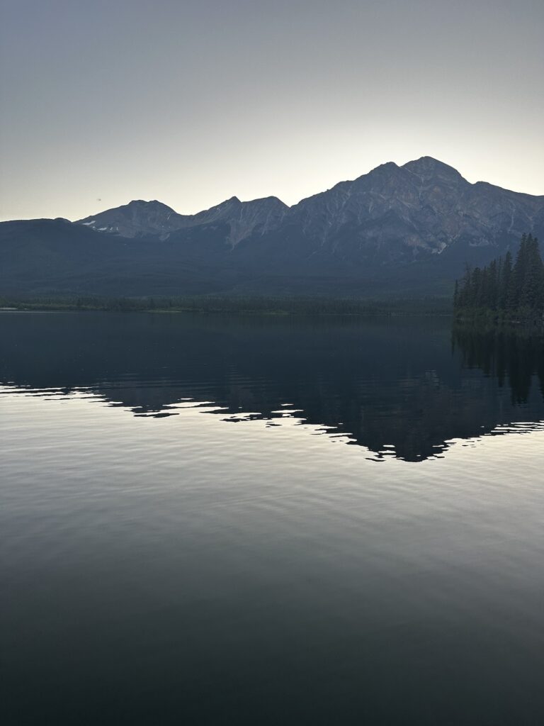 Mountain with golden sky behind and lake in front 