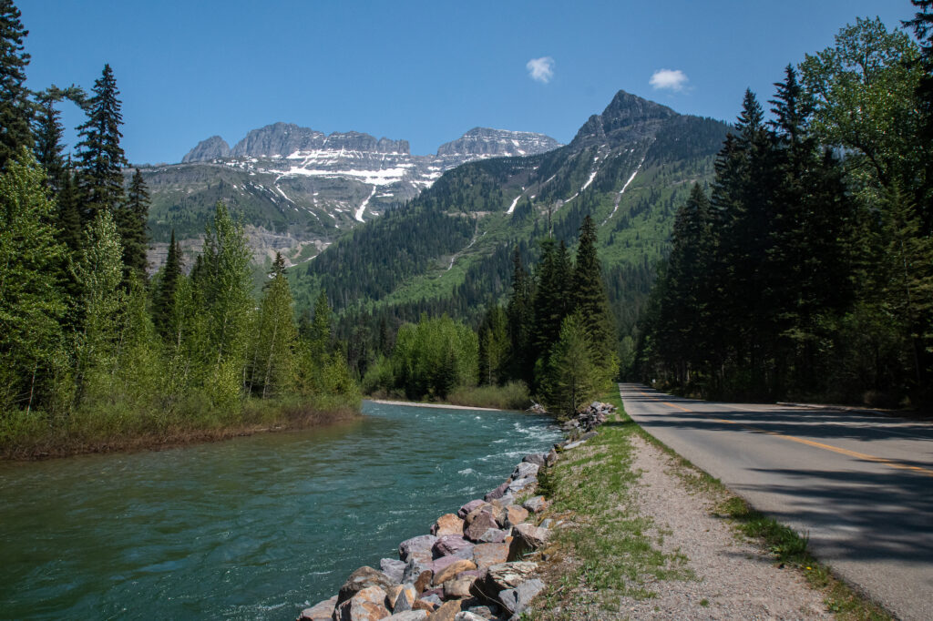 river next to road leading to tall mountains
