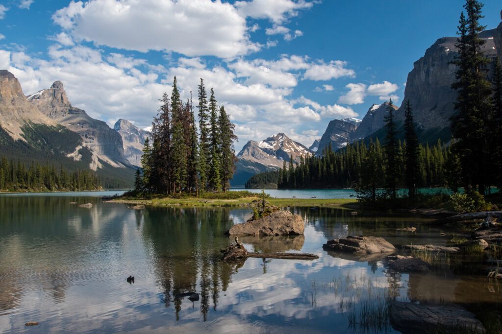 spirit island with reflections of mountains in water and blue lake, most stunning area ever