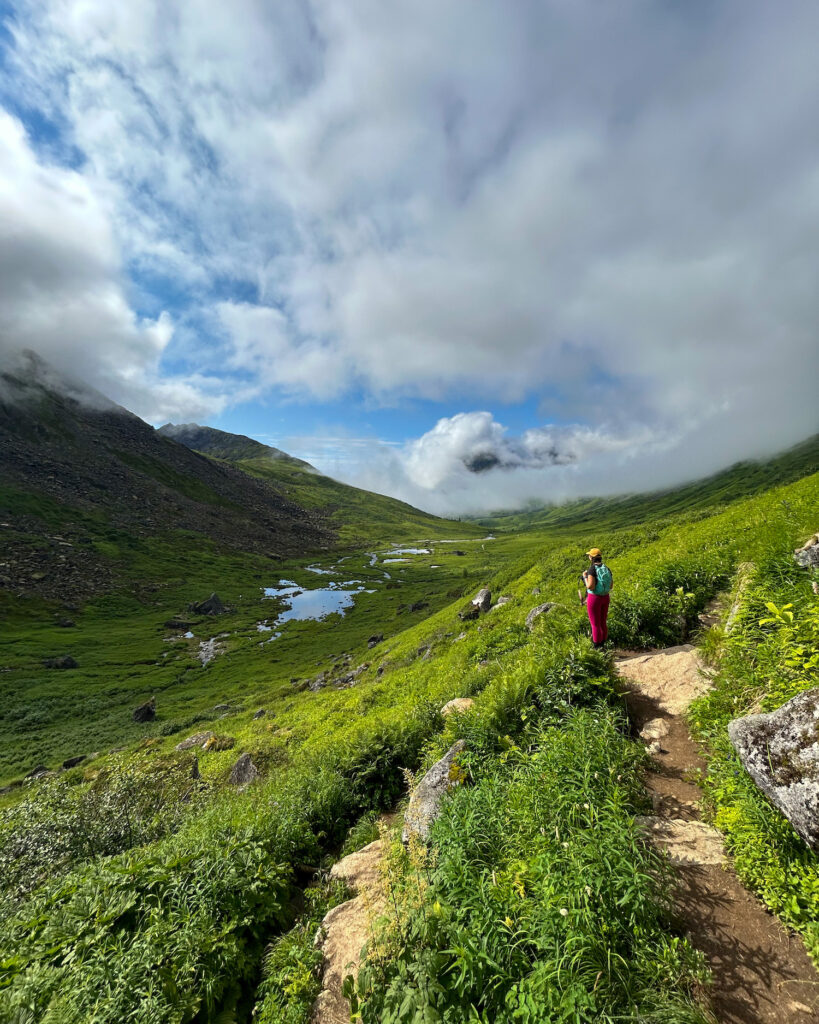 Girl on a very lush trail with fog behind her