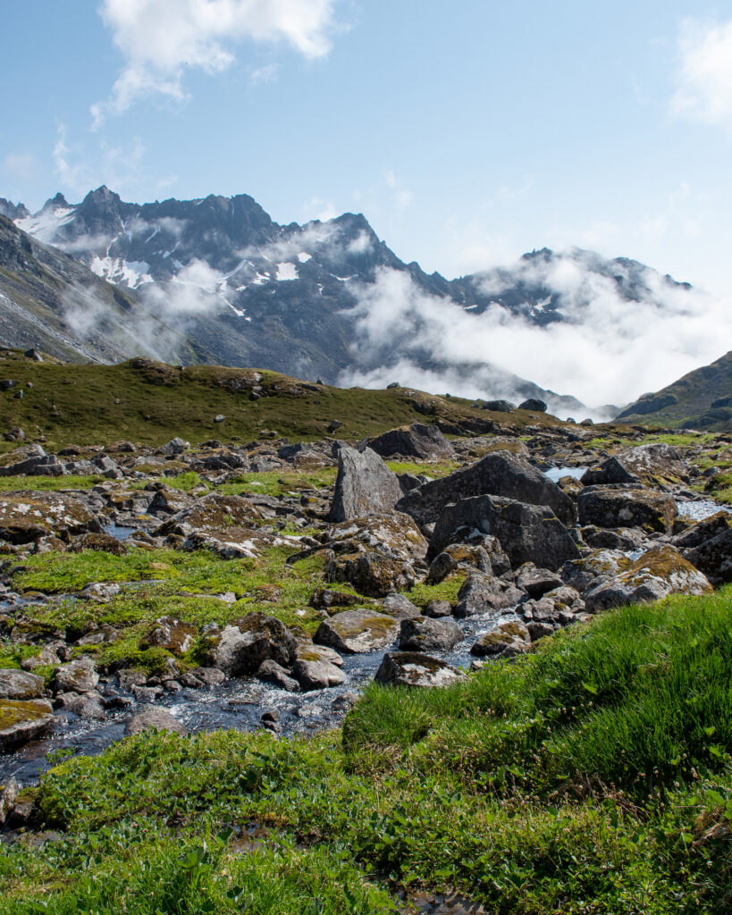 Rocky portion of trail with mountains and fog in the back