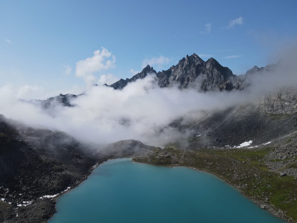 View of moutnains with fog and grogeous blue lake