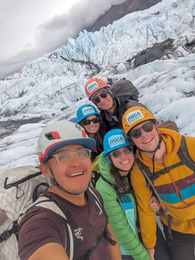 a group of people taking a selfie on a glacier