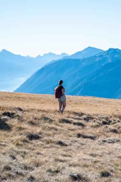 Girl walking through hillside in front of blue mountains