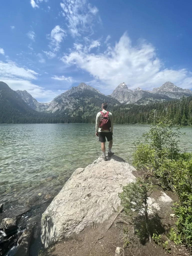 boy standing on a rock in front of taggart lake