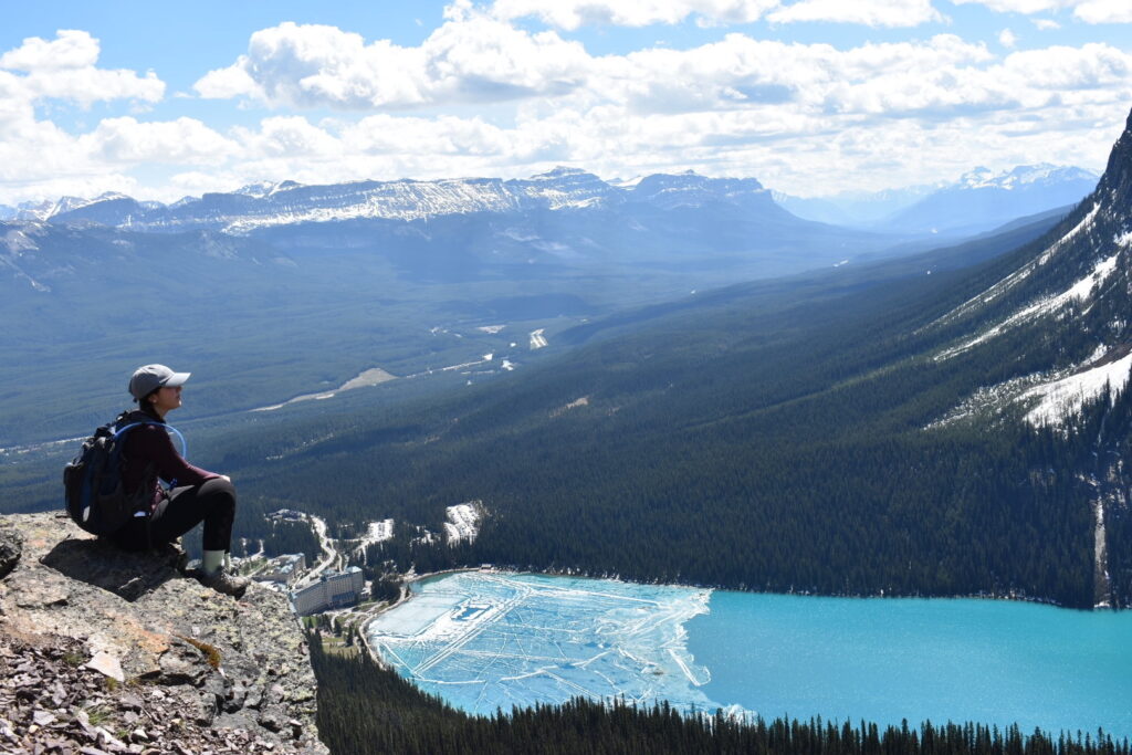 Girl sitting on a rock looking over Lake Louise and Fairmont