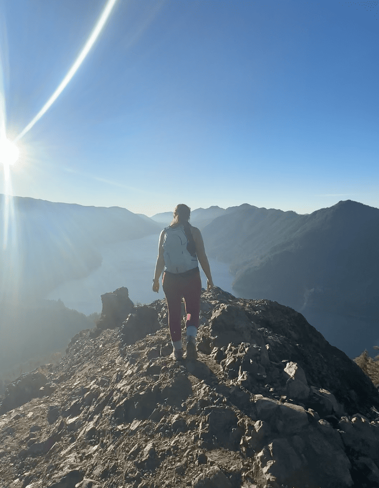 Girl walking over boulders at summit