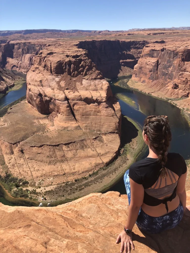 girl sitting next to horseshoe bend in page arizona