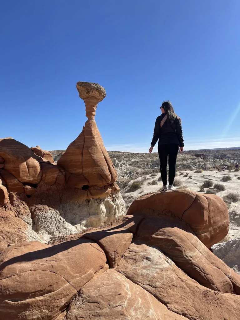 Girl standing next to toadstool rock formation