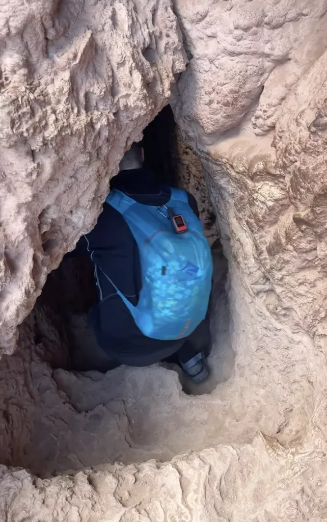 guy walking through cave of Mooney Falls