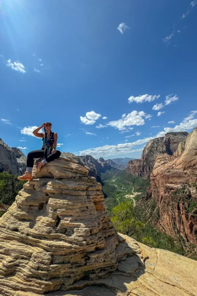 girl sitting on top of rock pile on angels landing in zion
