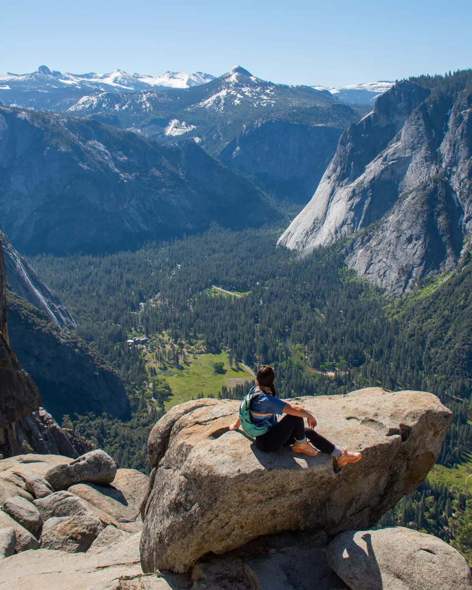 girl sitting on rock overlooking yosemite valley