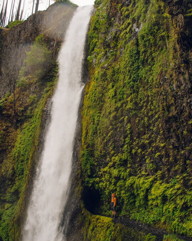 guy standing next to tunnel falls