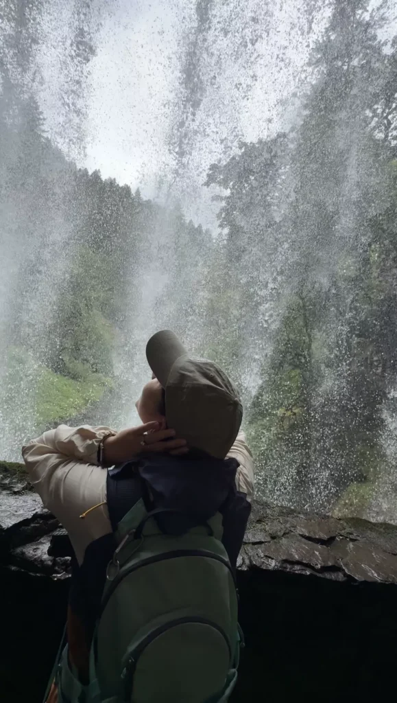 girl standing behind fall at trail of ten falls