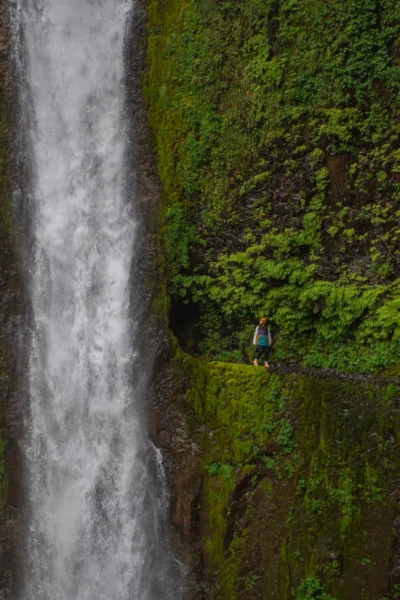Girl standing by tunnel falls opening