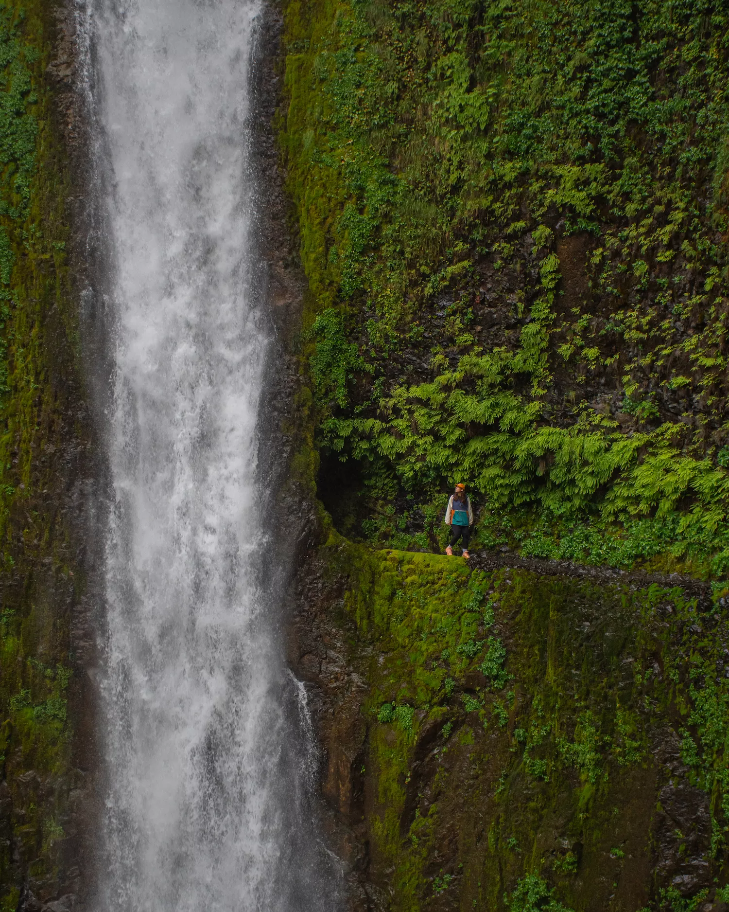 Girl standing by tunnel falls opening