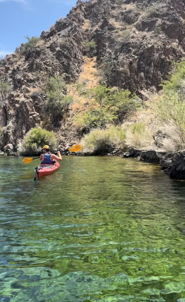 girl kayaking through green water