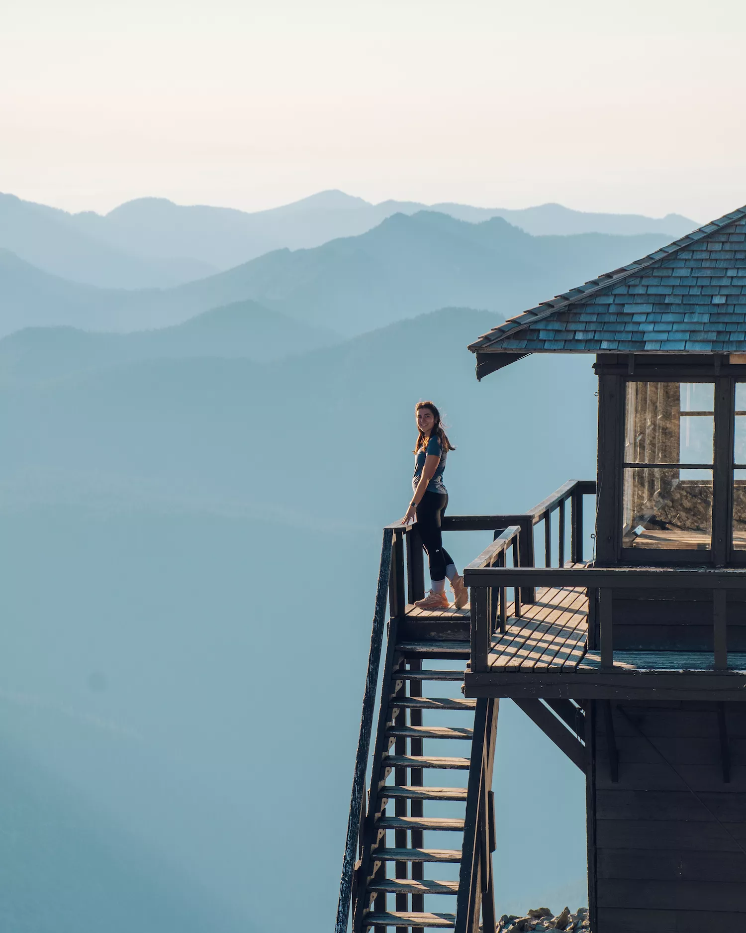 girl standing on firetower and smiling at camera