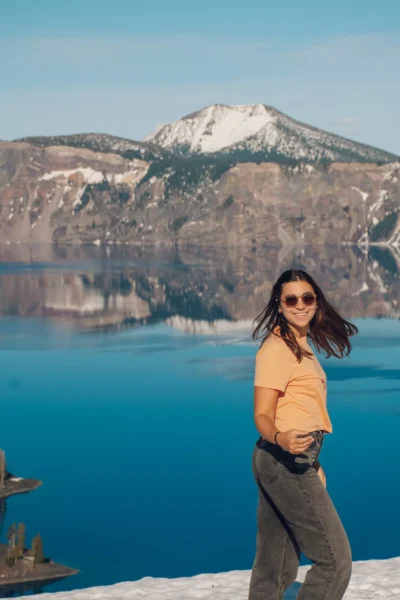 girl smiling and standing in front of Crater Lake