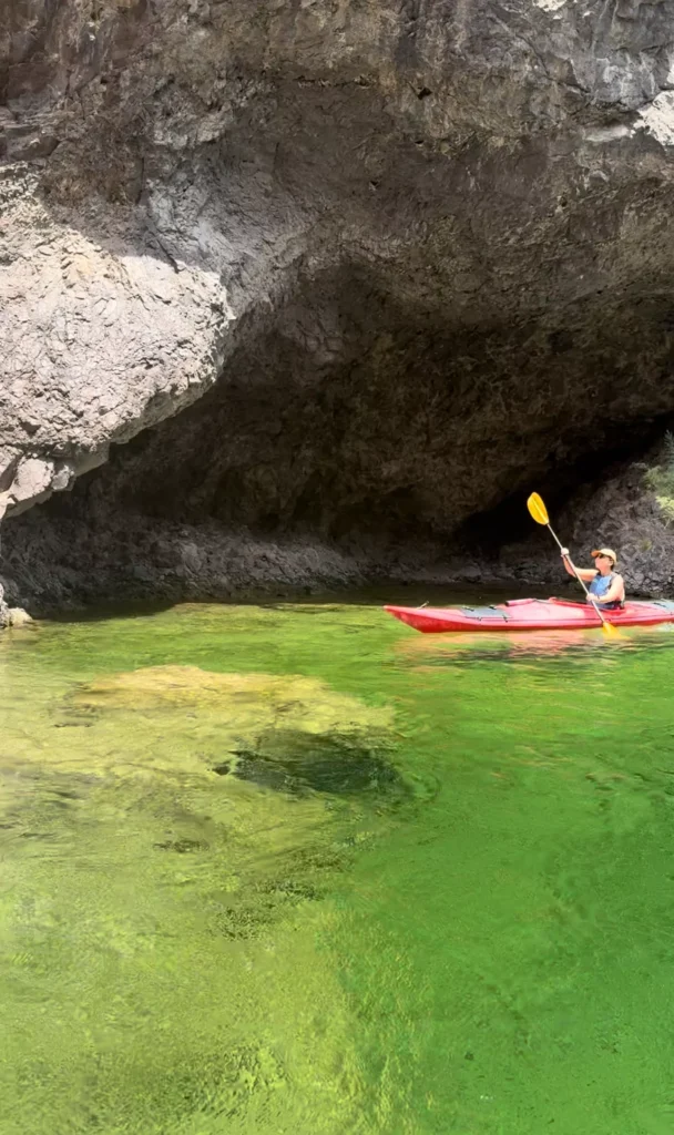 girl kayaking thorugh emerald cave
