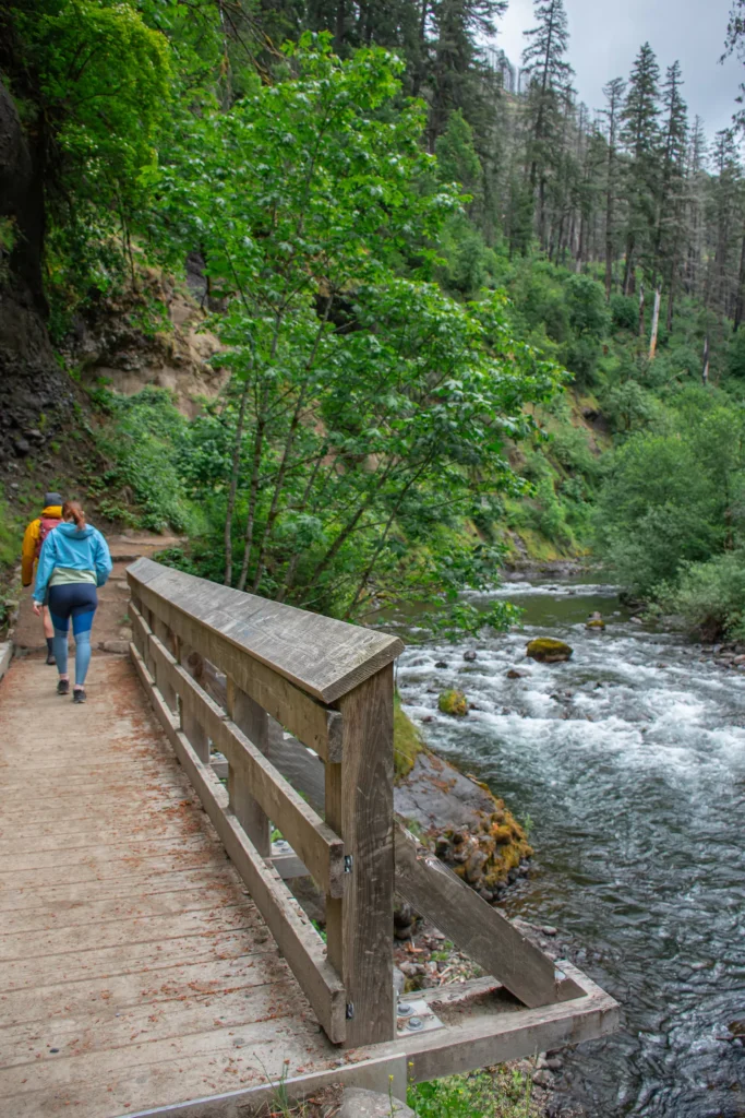 two people walking on a bridge in Eagle Creek