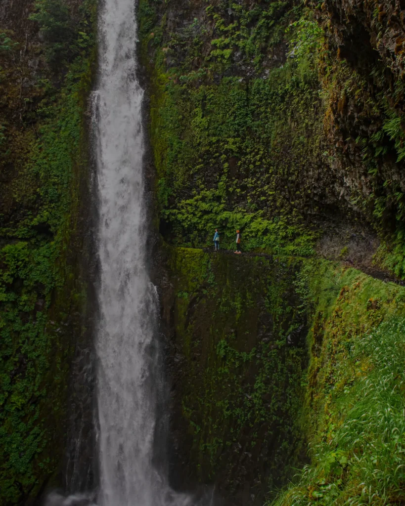 two people walking by tunnel falls