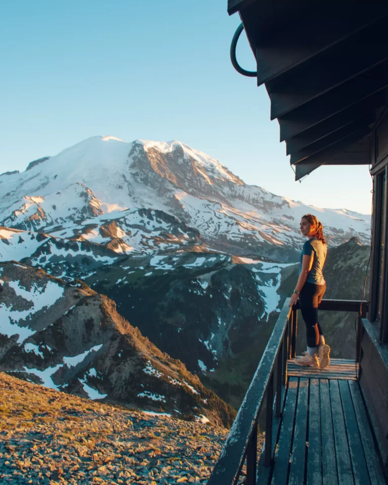 girl looking out from mt fremont lookout/firetower with mt rainier in the back