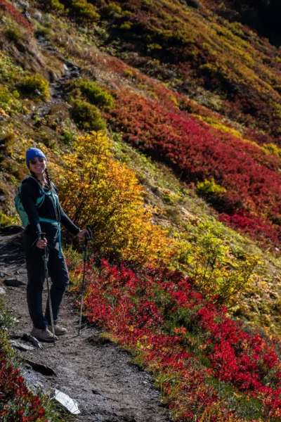 girl on trail covered in reds and yellows on a fall hike in washington