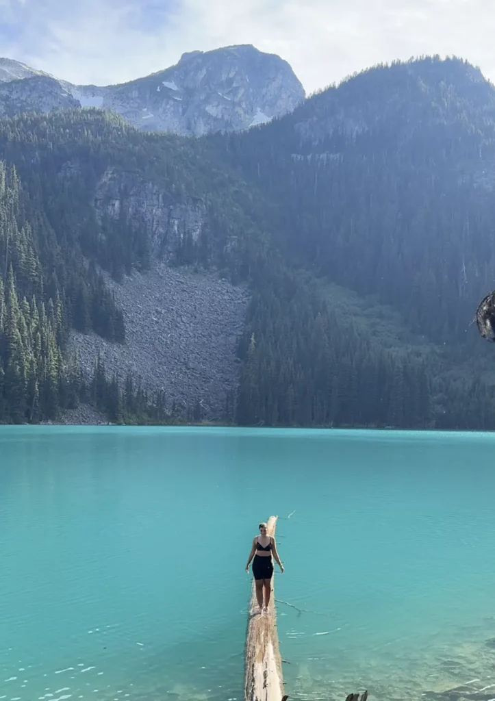 girl standing on log at middle joffre lakes