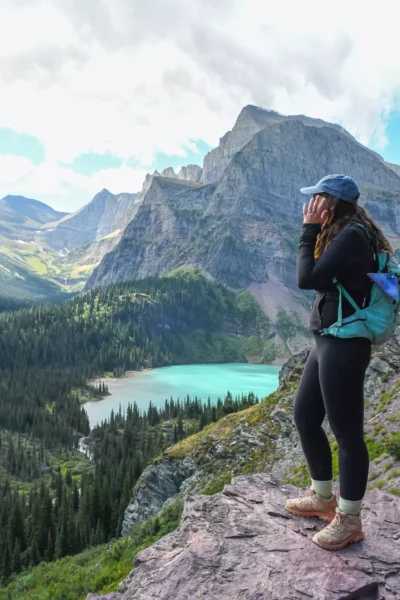 girl standing above grinnell lake on grinnell glacier trail