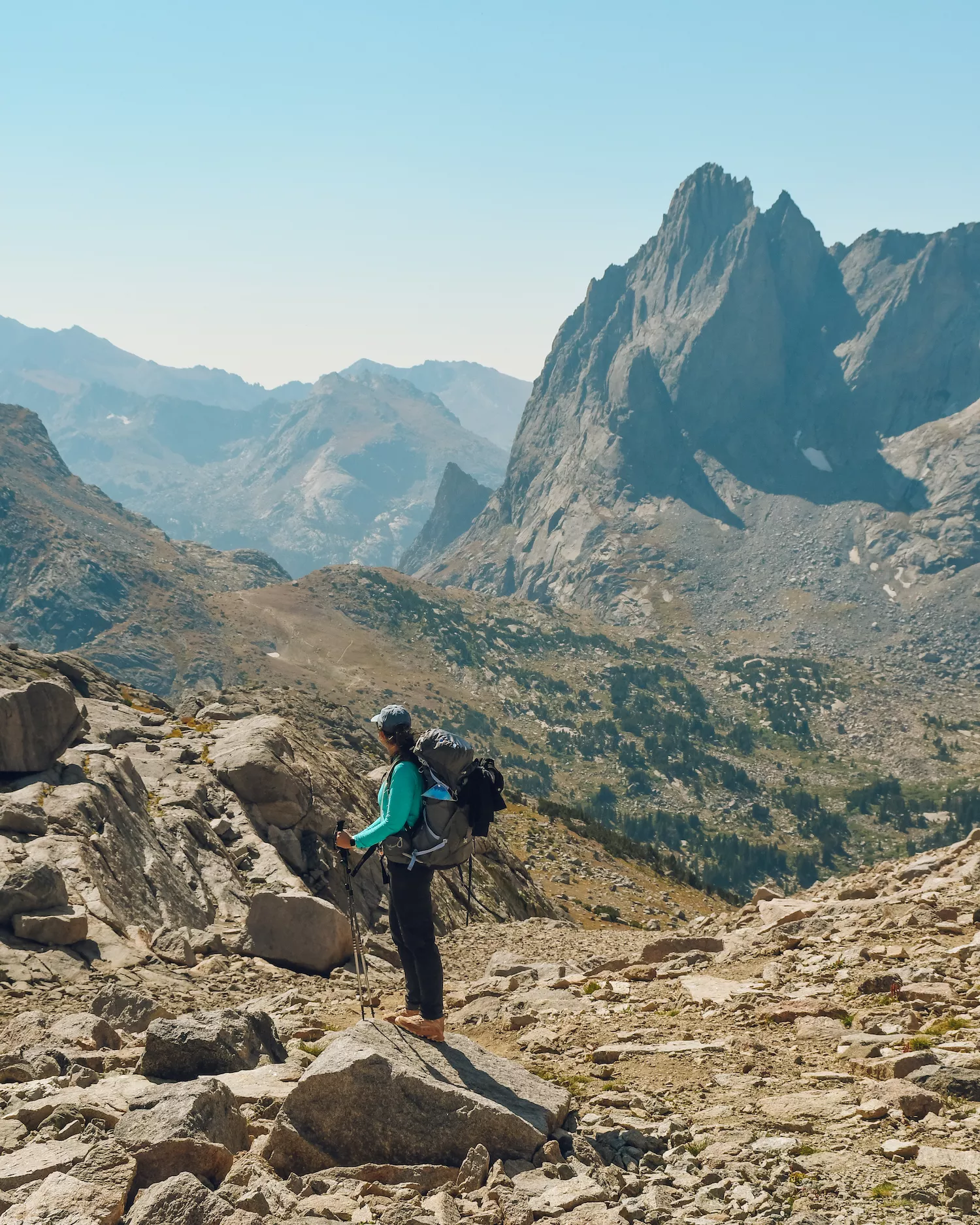 woman standing on a mountain with backpack on