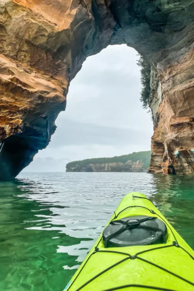 Painted Rocks in Michigan, with a kayak in front of an arch with a boat behind