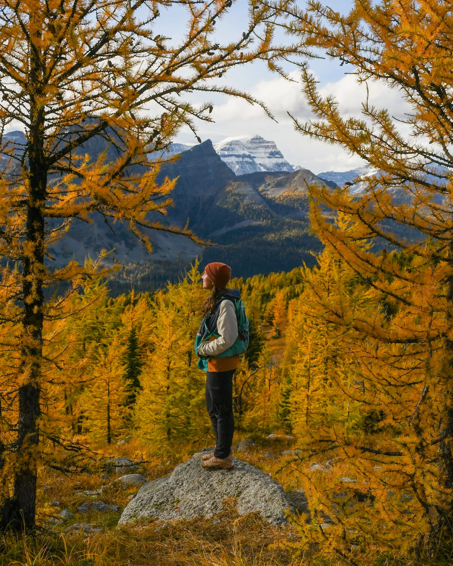 woman standing in the larches on Healy Pass
