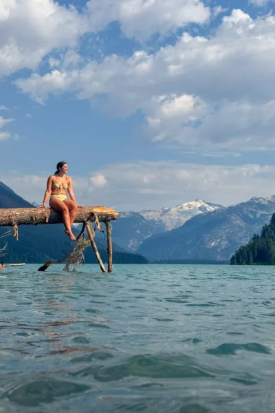 woman sitting on a tree over Cheakamus Lake