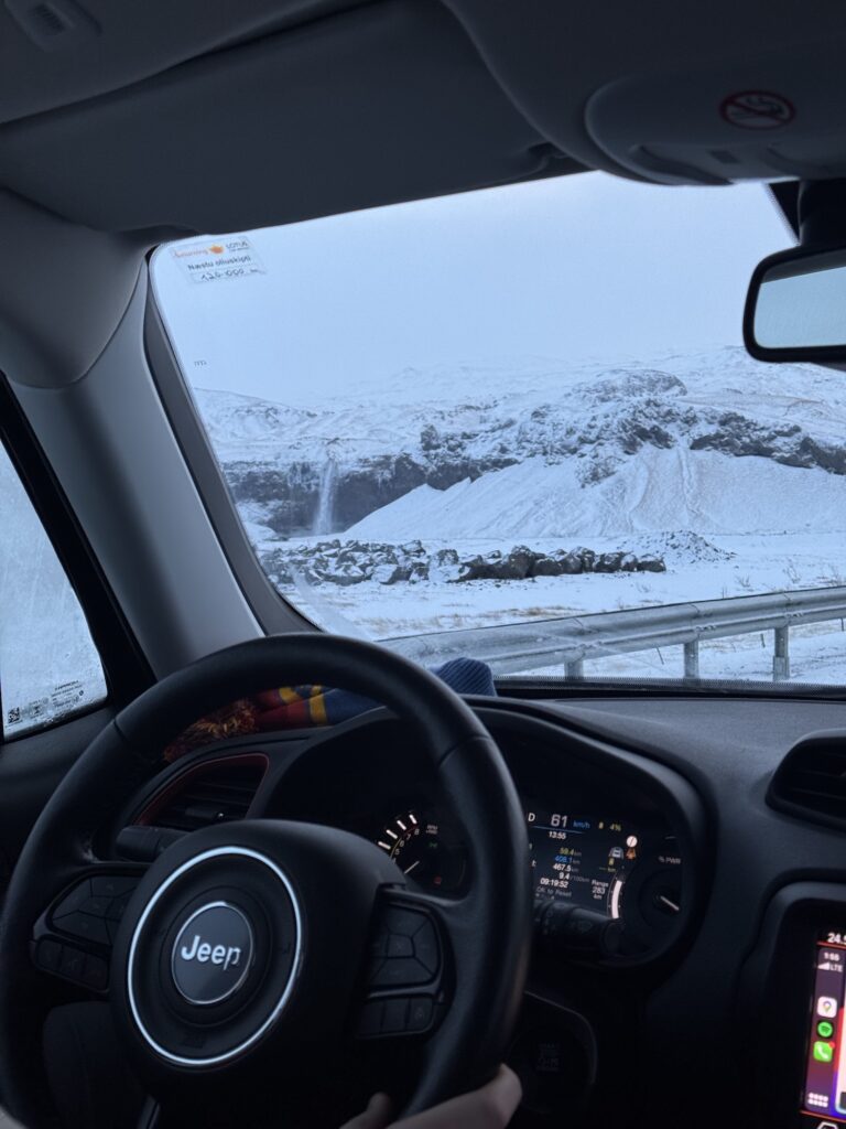 Driving in iceland during winter with waterfall out the window and snow covered conditions