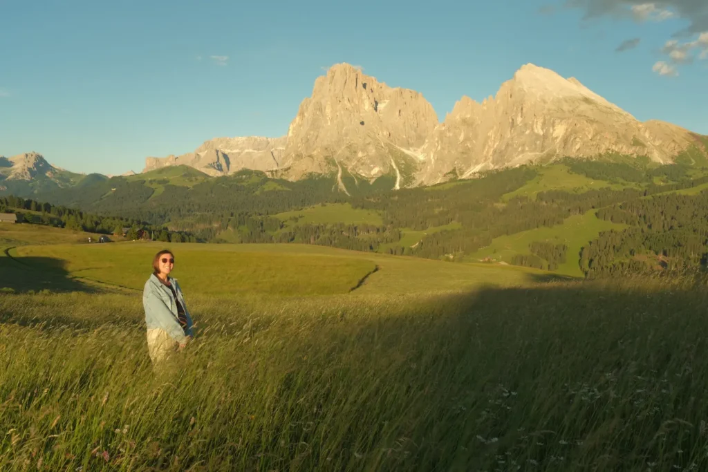 girl standing in Alpe Di Suisi meadow with golden light on her
