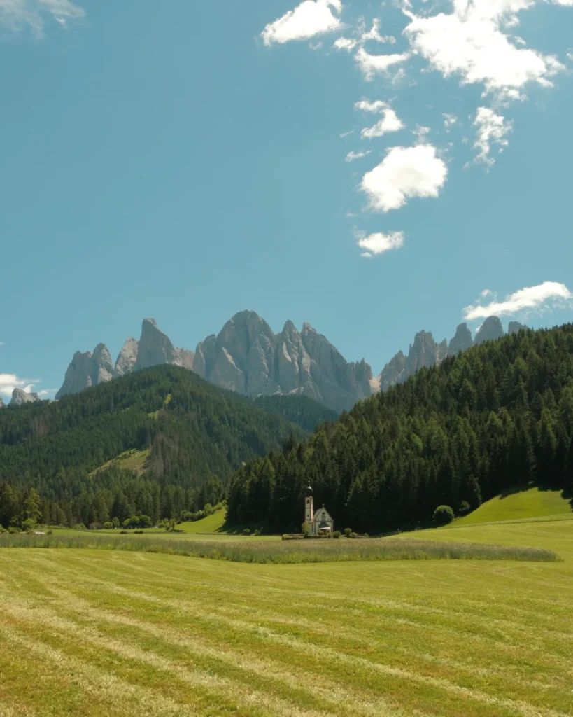 church of st john with tall mountain peaks overhead